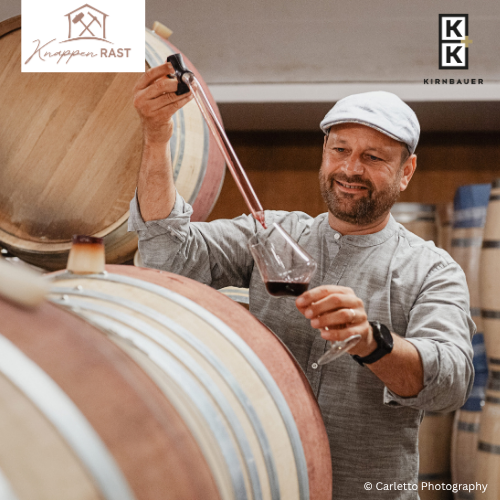 Winzer Kirnbauer bei den Fässern mit einem Rotwein